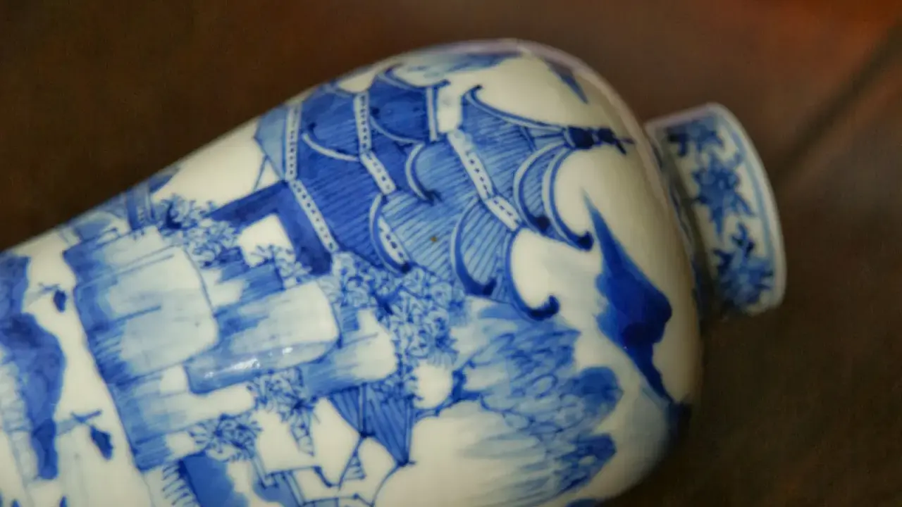 Vase en porcelaine bleue et blanche orné d'une scène complexe, portant un sceau porcelaine signature chinoise.