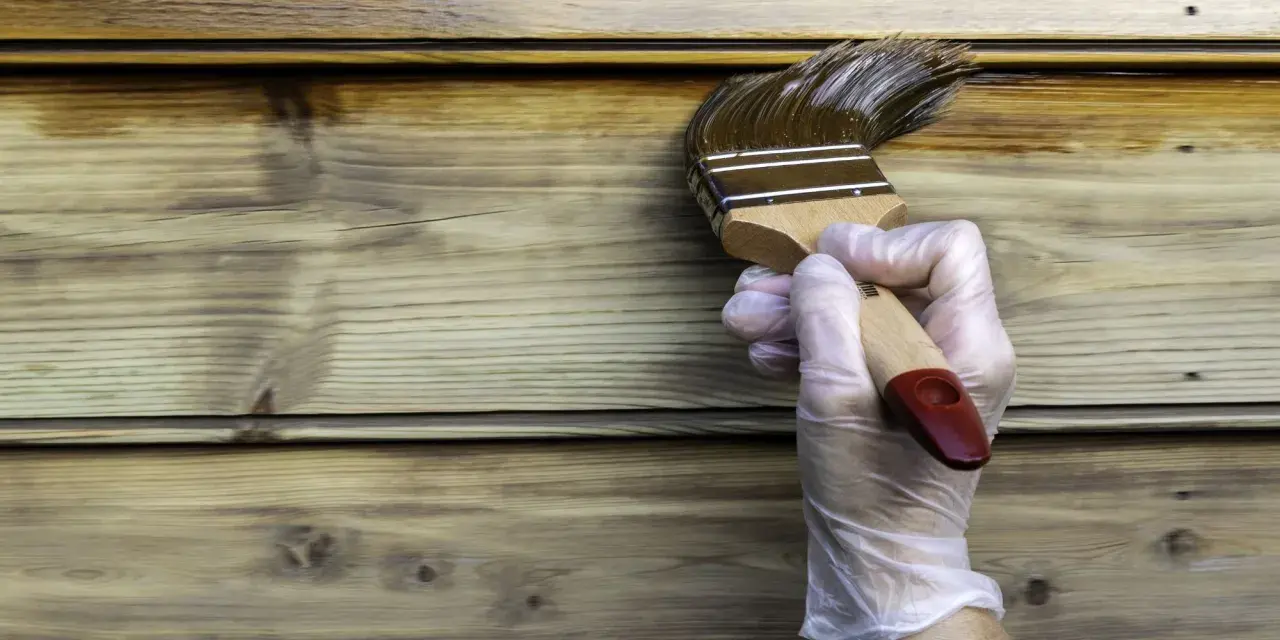 Application d'une lasure ou vernis bois extérieur sur des lames de bois. La protection du bois est en cours.