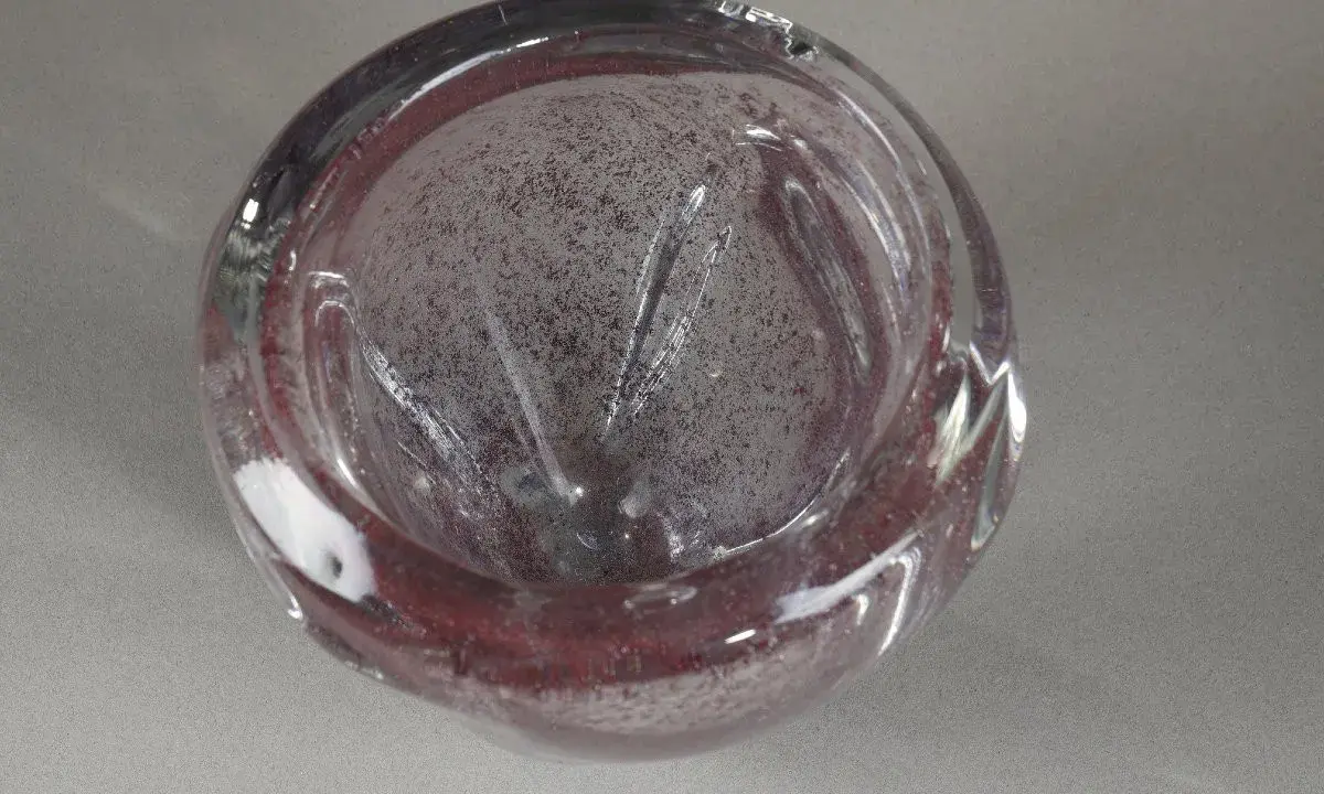 Un bol en verre soufflé, aux reflets pourpres et inclusions, évoquant l'art de André Thuret.