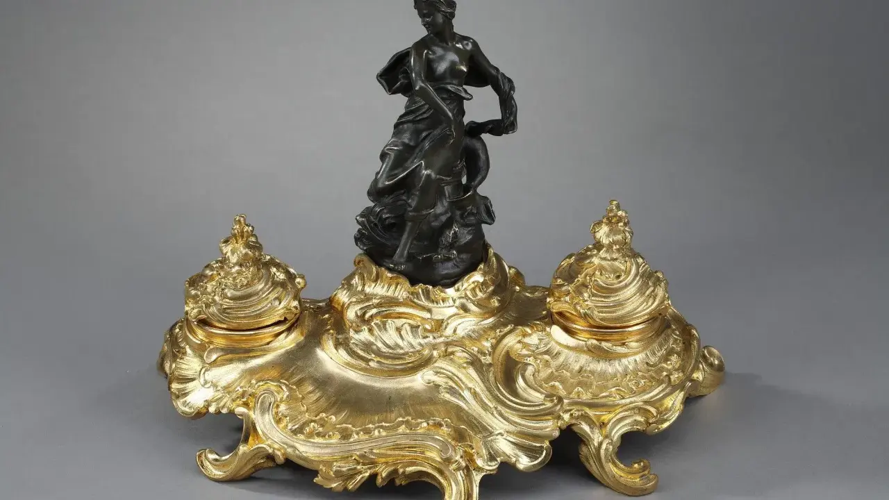 Encre dorée rocaille, ornée d'une femme drapée et d'un dauphin, évoquant l'élégance de l'époque Louis XV.