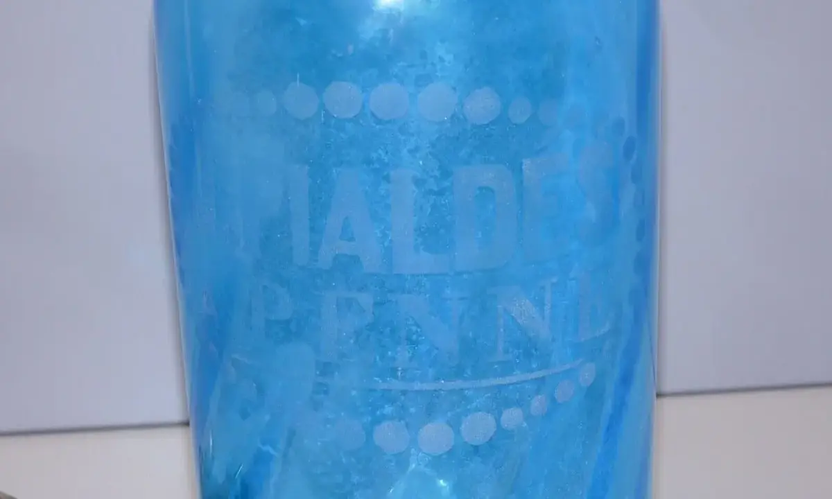 Bouteille ancienne en verre bleu pour eau de seltz, gravée "EAUX DE PENNES". Un objet de collection qui évoque le prix d'une eau gazeuse d'antan.