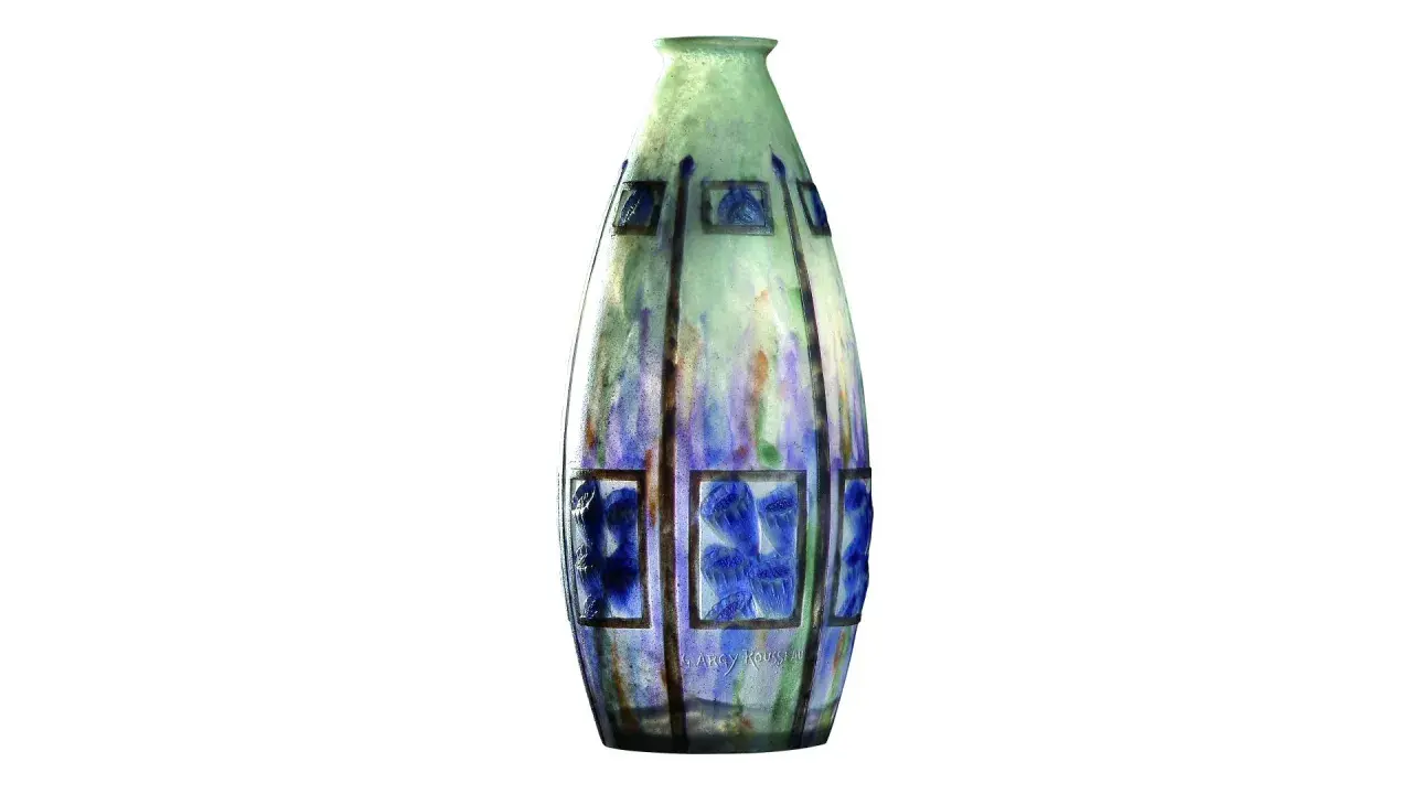 Vase élancé en verre soufflé, aux tons verts et bleus, orné de motifs floraux stylisés dans des cadres rectangulaires. Une œuvre signée G. Argy Rousseau.