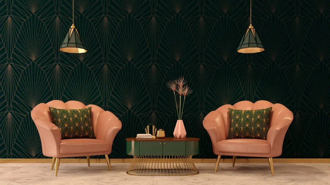Deux fauteuils roses velours, coussins verts art déco, sur fond de papier peint géométrique sombre.