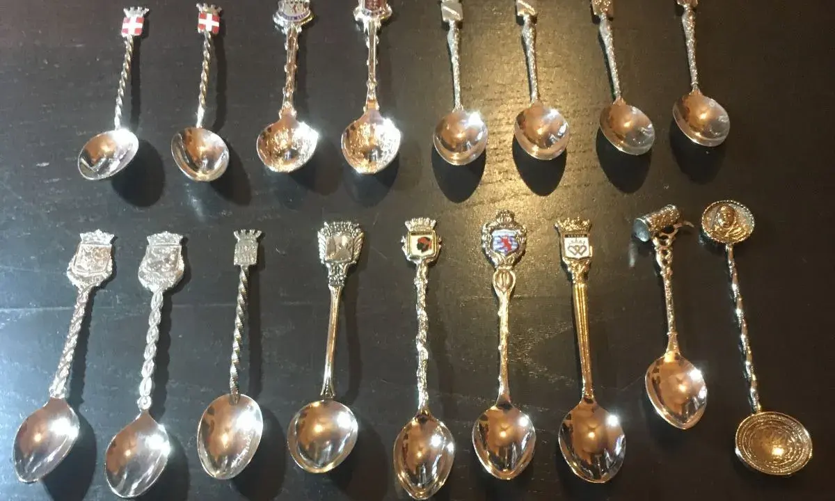 Collection de petites cuillères décoratives, chacune ornée d'un blason ou d'un symbole, révélant la valeur des petites cuillères de collection.
