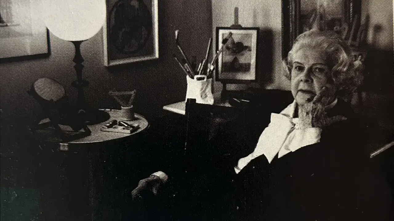Colette Gueden, artiste peintre, dans son atelier, entourée de ses œuvres et de son matériel.