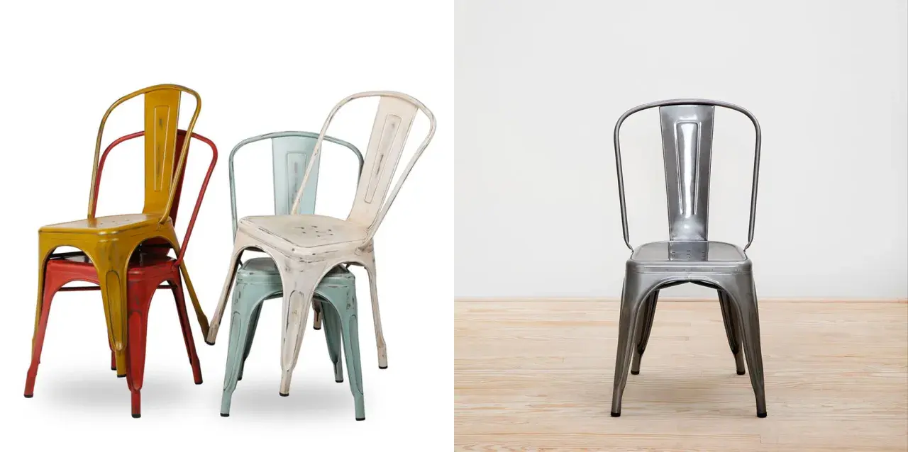 Empilement de chaises en métal colorées, style industriel, rappelant l'héritage de tolix la manufacture. Une chaise argentée se tient seule sur un parquet.
