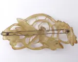 Pince à cheveux Art Nouveau en corne sculptée, évoquant le style de Lucien Gaillard, avec des motifs floraux et une libellule.