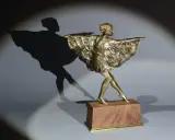 Sculpture en bronze d'une danseuse par Marcel Bouraine, sa robe à volants flottant, projetant une ombre gracieuse.