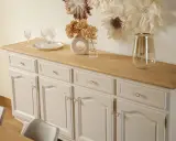 Buffet année 30 repeint, avec un plateau en bois clair. Des verres et un vase décorent le dessus.