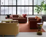 Salon moderne avec canapés confortables, tables basses et plantes vertes. Le mobilier Hurel apporte une touche d'élégance.