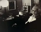 Colette Gueden, artiste peintre, dans son atelier, entourée de ses œuvres et de son matériel.
