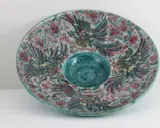 Plat décoratif en céramique, style Édouard Cazaux, orné d'oiseaux stylisés et de fleurs, avec un centre creux bleu turquoise.