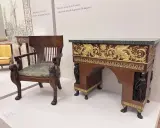 Fauteuil et bureau de style consulat, ornés de lions sculptés et de sphinx dorés, évoquant le cabinet de travail du général Bonaparte.