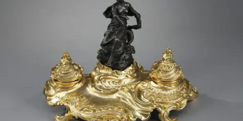Encre dorée rocaille, ornée d'une femme drapée et d'un dauphin, évoquant l'élégance de l'époque Louis XV.