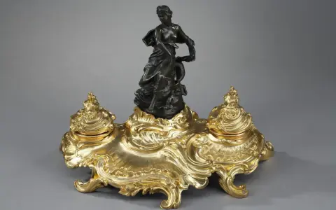 Encre dorée rocaille, ornée d'une femme drapée et d'un dauphin, évoquant l'élégance de l'époque Louis XV.