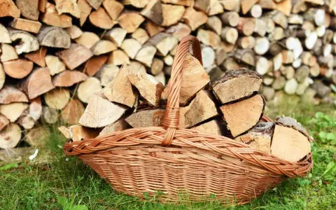 Panier en osier rempli de bois de chauffage, prêt à être utilisé pour protéger le bois de l'humidité.