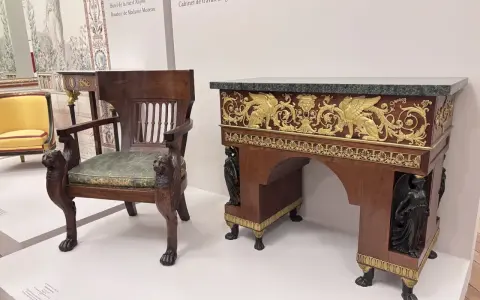 Fauteuil et bureau de style consulat, ornés de lions sculptés et de sphinx dorés, évoquant le cabinet de travail du général Bonaparte.
