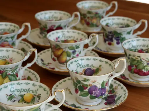 Service à thé en porcelaine anglaise, orné de fruits variés : citrons, prunes, raisins, cerises, poires, pamplemousses.