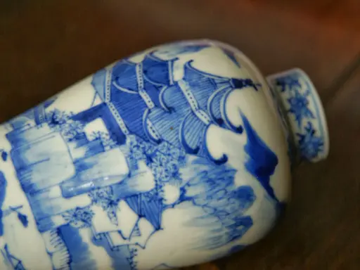 Vase en porcelaine bleue et blanche orné d'une scène complexe, portant un sceau porcelaine signature chinoise.
