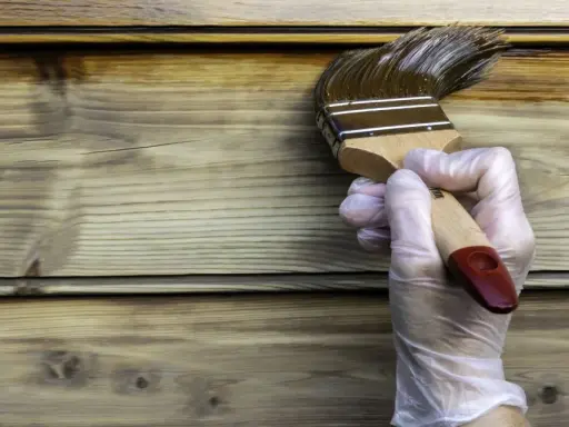 Application d'une lasure ou vernis bois extérieur sur des lames de bois. La protection du bois est en cours.
