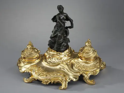 Encre dorée rocaille, ornée d'une femme drapée et d'un dauphin, évoquant l'élégance de l'époque Louis XV.