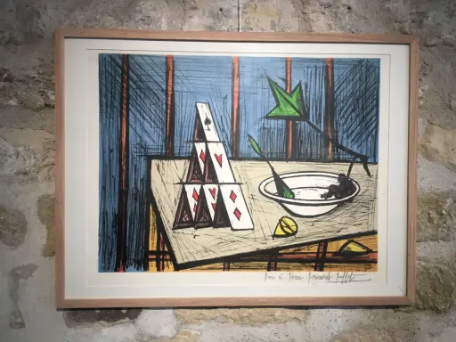 Lithographie de Bernard Buffet, une tour de cartes fragile, symbole de la valeur éphémère des choses. Une nature morte intrigante.