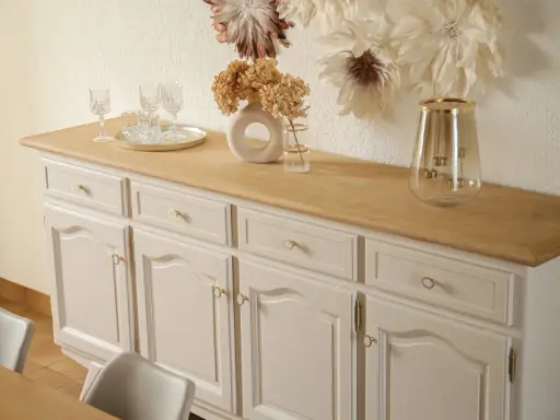 Buffet année 30 repeint, avec un plateau en bois clair. Des verres et un vase décorent le dessus.
