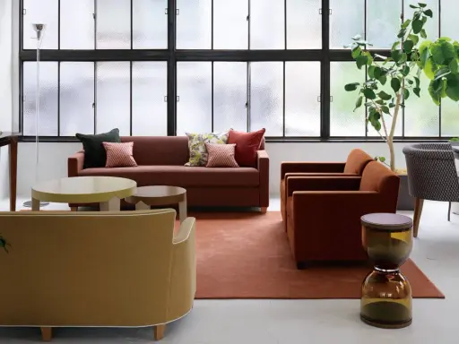 Salon moderne avec canapés confortables, tables basses et plantes vertes. Le mobilier Hurel apporte une touche d'élégance.