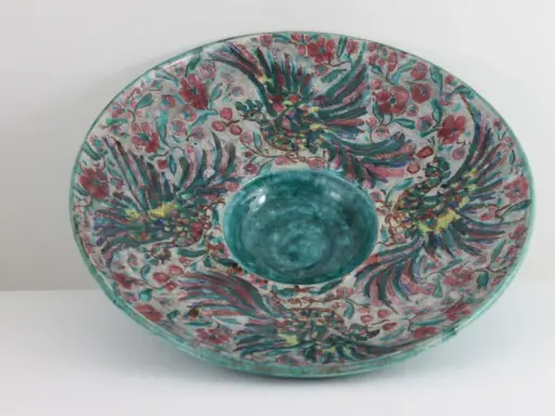 Plat décoratif en céramique, style Édouard Cazaux, orné d'oiseaux stylisés et de fleurs, avec un centre creux bleu turquoise.
