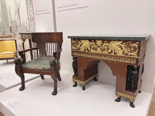 Fauteuil et bureau de style consulat, ornés de lions sculptés et de sphinx dorés, évoquant le cabinet de travail du général Bonaparte.