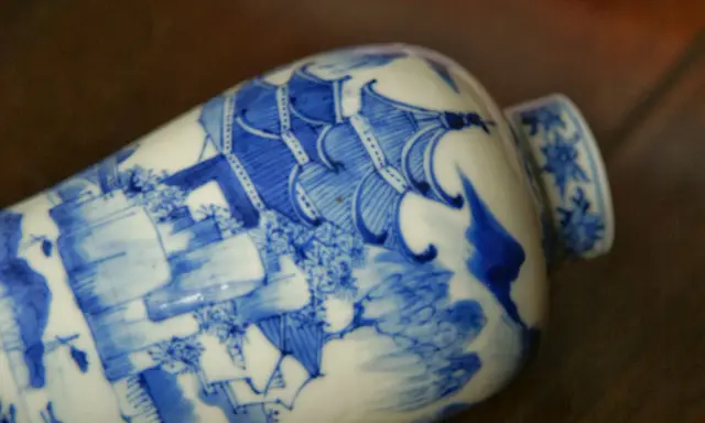 Vase en porcelaine bleue et blanche orné d'une scène complexe, portant un sceau porcelaine signature chinoise.