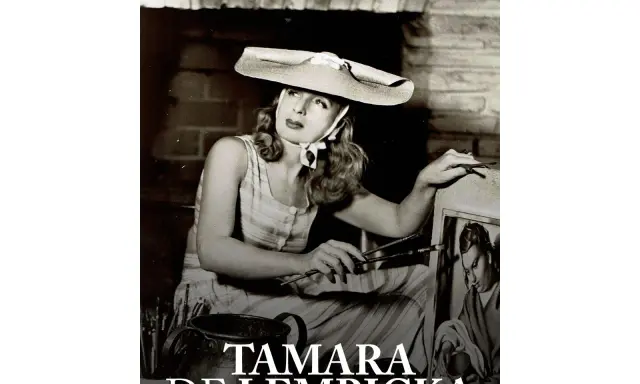 Tamara de Lempicka, artiste peintre, esquisse une œuvre. Son chapeau large et sa robe rayée évoquent le style Art déco de ses œuvres d'art.