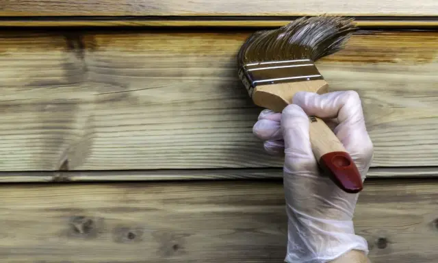 Application d'une lasure ou vernis bois extérieur sur des lames de bois. La protection du bois est en cours.