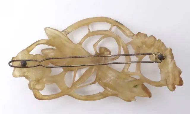 Pince à cheveux Art Nouveau en corne sculptée, évoquant le style de Lucien Gaillard, avec des motifs floraux et une libellule.