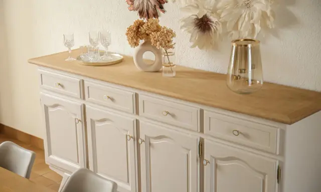 Buffet année 30 repeint, avec un plateau en bois clair. Des verres et un vase décorent le dessus.