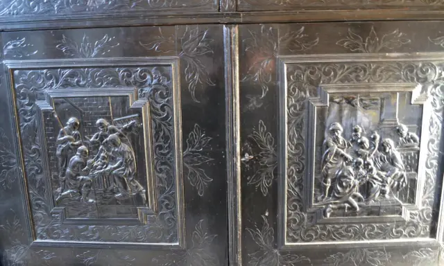Détail d'un meuble Louis XIII sculpté de scènes bibliques et de motifs floraux.