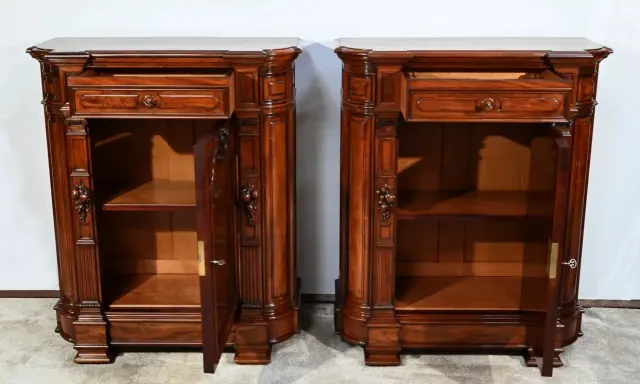Paire de commodes en bois sombre, style mobilier Napoléon III, avec tiroirs et portes sculptées.