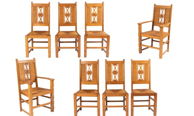 Ensemble de chaises en bois clair, style Charles Dudouyt, avec assises en paille tressée et dossiers ornés de motifs géométriques.