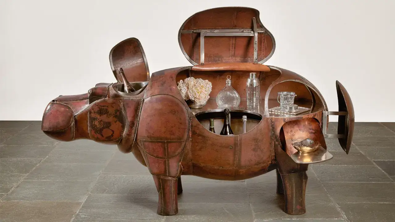 &Eacute;l&eacute;gante sculpture Lalanne en forme d'hippopotame, bar ouvert r&eacute;v&eacute;lant bouteilles, verres et shaker.