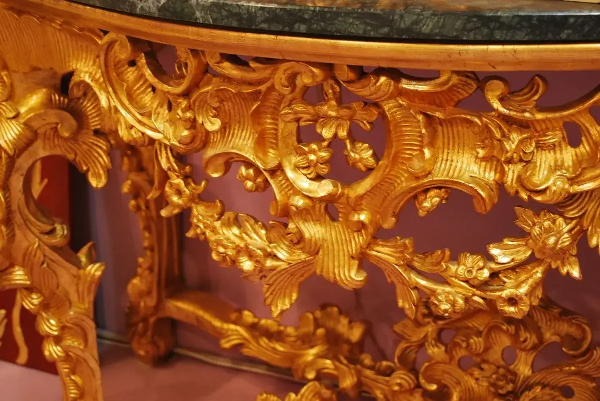 Détail d'une console dorée aux ornements floraux complexes, typiques de l'architecture baroque.