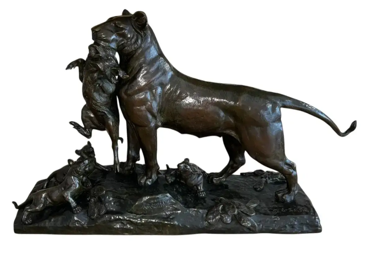 Lionne portant un jeune sanglier, entour&eacute;e de ses lionceaux. Sculpture en bronze par Auguste Cain.