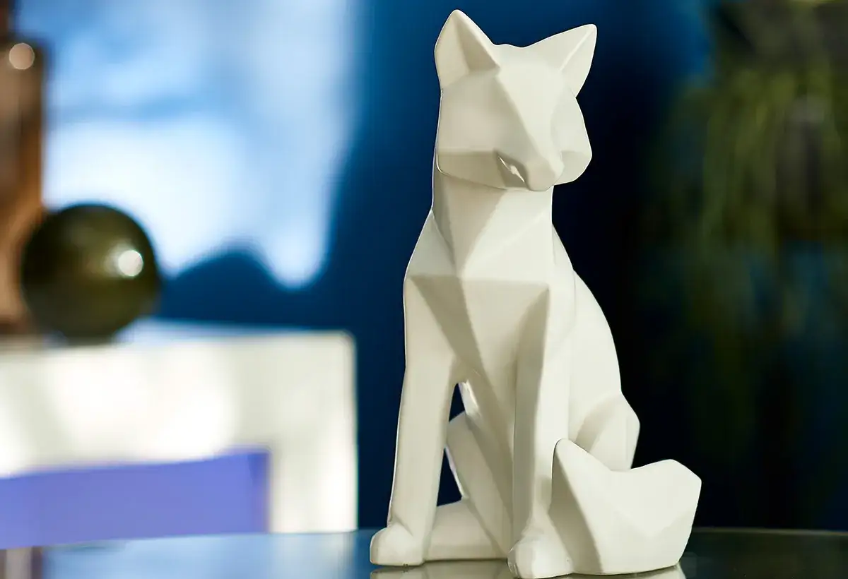 Une sculpture de renard blanc aux formes géométriques, typique des sculpteurs animaliers modernes.