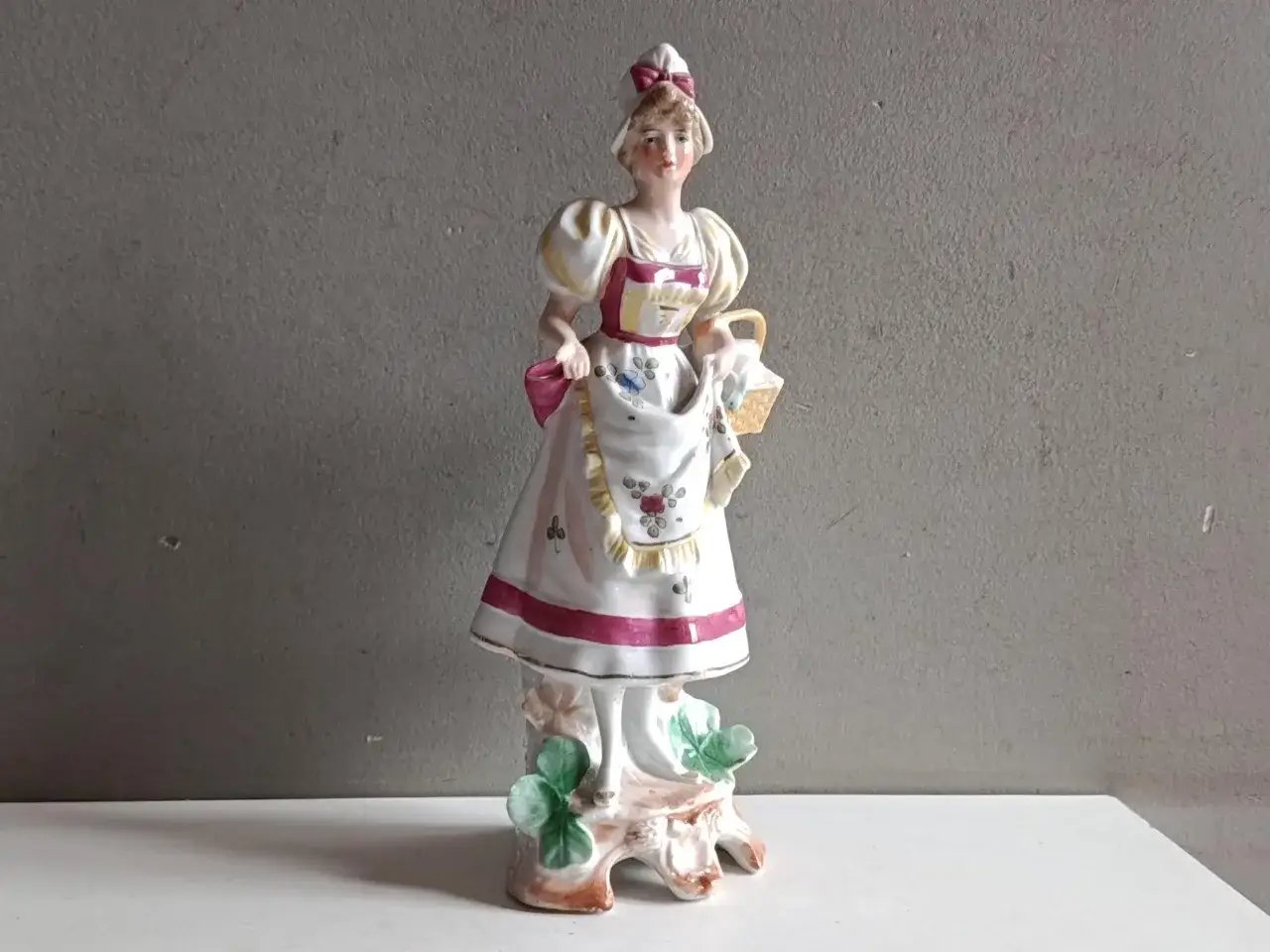 Estimation sujet en biscuit ancien : figurine d'une jeune femme en robe à tablier, tenant un panier.