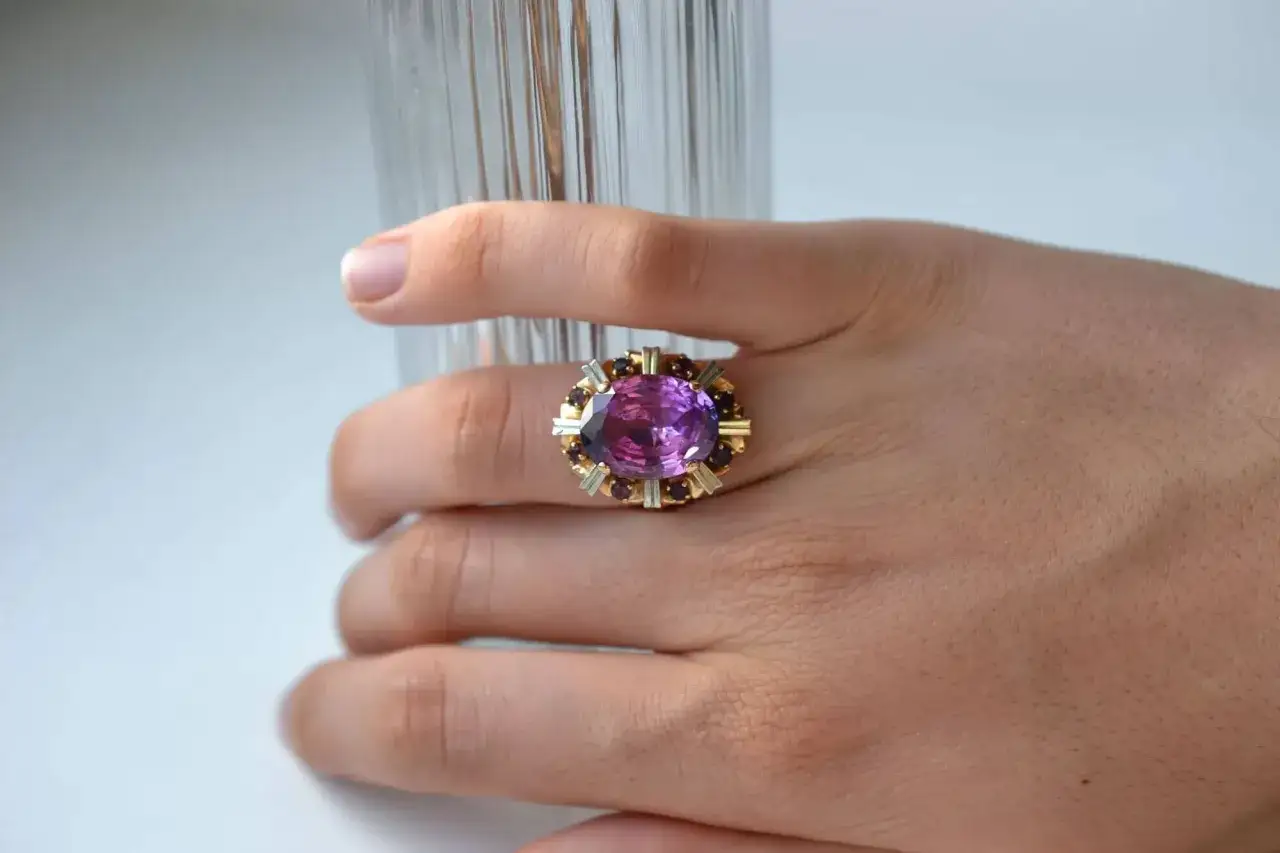 Bague or jaune avec une grosse améthyste ovale entourée de petits grenats. Une pièce de joaillerie pour une estimation bijoux diamant.