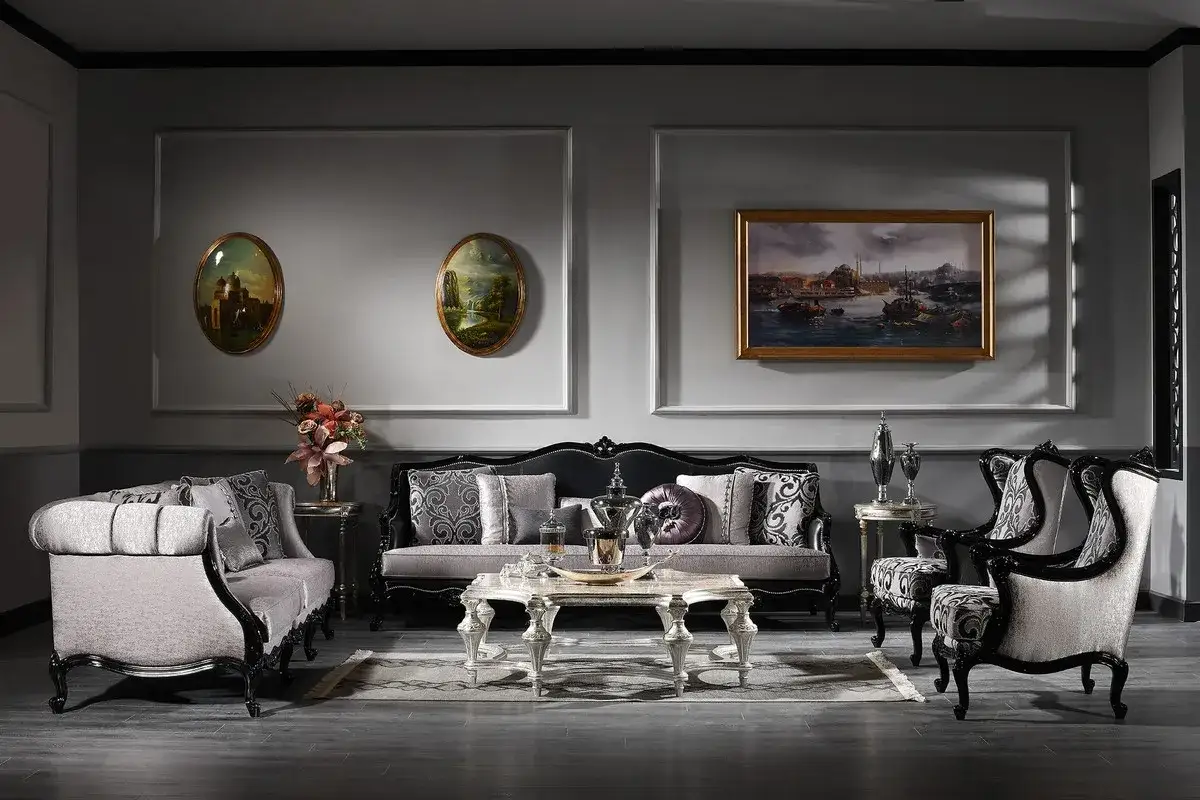 Salon luxueux au style baroque, avec canapés, fauteuils, table basse ornée et tableaux.