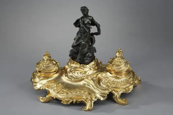 Encre dorée rocaille, ornée d'une femme drapée et d'un dauphin, évoquant l'élégance de l'époque Louis XV.