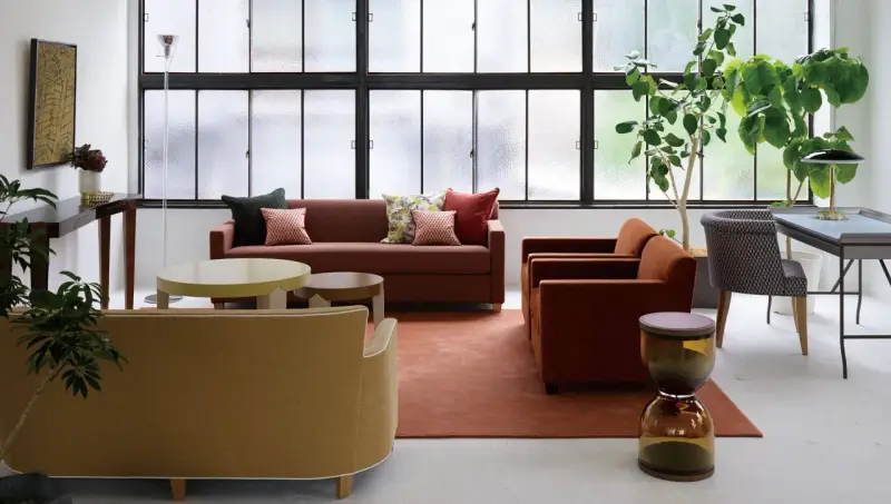 Salon moderne avec canapés confortables, tables basses et plantes vertes. Le mobilier Hurel apporte une touche d'élégance.
